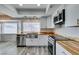 Well-lit kitchen boasting stainless steel appliances, white cabinets, butcher block counters, and an adjacent dining area at 6357 Vicuna Dr, Las Vegas, NV 89146