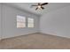 Bright bedroom features plush carpet, ceiling fan, and two large windows at 660 Otter Brook St, Henderson, NV 89011