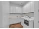 Well-lit laundry room boasts white cabinets and modern washer and dryer at 660 Otter Brook St, Henderson, NV 89011