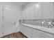 Laundry Room with cabinets, countertop, tile backsplash and door to outside at 660 Otter Brook St, Henderson, NV 89011