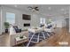 Open concept living room with fireplace, white sofas, blue pillows and views to the dining area at 660 Otter Brook St, Henderson, NV 89011