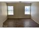 Bedroom featuring wood-look tile flooring and two windows, providing natural light at 6632 Coastal Breeze Ct, Las Vegas, NV 89108