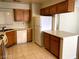 Bright kitchen featuring wooden cabinets, tile floors, white appliances and a convenient kitchen island at 6632 Coastal Breeze Ct, Las Vegas, NV 89108