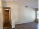 Living room with a vaulted ceiling, wood floors, and a hallway with pantry access at 6632 Coastal Breeze Ct, Las Vegas, NV 89108