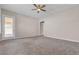 Empty bedroom with neutral paint, carpeted floors, access to backyard, and a ceiling fan at 665 Look Lively Ct, Henderson, NV 89011
