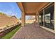 A covered patio with a paver floor, a view of the backyard, and access to the house at 665 Look Lively Ct, Henderson, NV 89011
