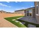 A serene backyard features artificial turf, a stone patio, and stepping stones creating a relaxing outdoor space at 70 Pikiariki Ct, Las Vegas, NV 89183