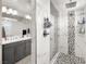 Modern bathroom featuring a glass-enclosed shower with tile surround, pebble floor, and double sink vanity at 70 Pikiariki Ct, Las Vegas, NV 89183