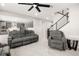 Spacious open-concept living room featuring gray furniture, an open staircase and seamless flow to the kitchen at 70 Pikiariki Ct, Las Vegas, NV 89183