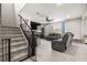 Open-concept living room featuring a staircase, modern furnishings, and bright, airy atmosphere at 70 Pikiariki Ct, Las Vegas, NV 89183