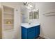Bright bathroom featuring a blue vanity, white sink, and a storage shelf at 702 Carlitos Ave, North Las Vegas, NV 89031