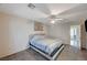 This bedroom features carpet, a queen-sized bed, a ceiling fan, and an open doorway at 702 Carlitos Ave, North Las Vegas, NV 89031