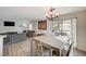 Open concept living room and dining area with sliding glass door at 702 Carlitos Ave, North Las Vegas, NV 89031