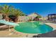 Backyard with a sparkling pool surrounded by lush landscaping and clear blue skies at 702 Carlitos Ave, North Las Vegas, NV 89031