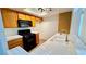 The cozy kitchen features wood cabinetry and a black range and microwave at 7100 Pirates Cove Rd # 1022, Las Vegas, NV 89145