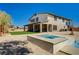 Spacious backyard featuring a pool, spa, desert landscaping, and a covered patio at 7736 Tioga Ridge Ct, Las Vegas, NV 89117
