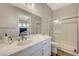 Bright bathroom with white vanity, quartz countertop, and glass-enclosed shower at 7736 Tioga Ridge Ct, Las Vegas, NV 89117