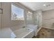 Bright bathroom with a large window over a bathtub and a glass enclosed shower at 7736 Tioga Ridge Ct, Las Vegas, NV 89117