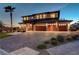 Exterior view of a modern home with a three-car garage and landscaped front yard at dusk at 7736 Tioga Ridge Ct, Las Vegas, NV 89117