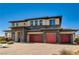 Contemporary two-story home featuring stone accents, three-car garage, and a brick driveway under a clear blue sky at 7736 Tioga Ridge Ct, Las Vegas, NV 89117