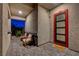 Cozy covered front porch with chairs, textured walls, and a unique door at 7736 Tioga Ridge Ct, Las Vegas, NV 89117