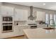 White cabinets, stainless appliances, and quartz countertops are featured in this modern kitchen at 7736 Tioga Ridge Ct, Las Vegas, NV 89117
