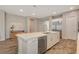 Kitchen island with stainless dishwasher and sink, white cabinetry, and wood-look tile flooring at 7736 Tioga Ridge Ct, Las Vegas, NV 89117