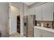 Kitchenette with stainless steel appliances, white cabinets, and access to a laundry area at 7736 Tioga Ridge Ct, Las Vegas, NV 89117