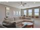 Cozy living room with sectional sofa, round coffee table, and many windows at 7736 Tioga Ridge Ct, Las Vegas, NV 89117