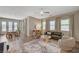 Spacious living room with large windows, dining table, modern decor, and hardwood-style flooring at 7736 Tioga Ridge Ct, Las Vegas, NV 89117