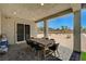 Covered patio with a dining table and chairs, overlooking the backyard and desert landscape at 7736 Tioga Ridge Ct, Las Vegas, NV 89117