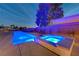 Modern backyard pool and hot tub featuring vibrant underwater lighting and landscaping at 7736 Tioga Ridge Ct, Las Vegas, NV 89117