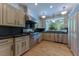 A bright kitchen featuring stainless steel appliances, natural wood floors and views of the outdoors at 7988 Pinnacle Peak Ave, Las Vegas, NV 89113