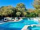 Backyard pool with lounge chairs and mature landscaping for privacy in a resort-style setting at 7988 Pinnacle Peak Ave, Las Vegas, NV 89113