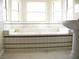Modern bathtub under bright windows with a white pedestal sink at 861 Mcmurray Dr, Pahrump, NV 89060