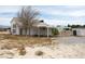 Two story white home with a covered carport and additional out building at 861 Mcmurray Dr, Pahrump, NV 89060