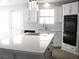 Bright kitchen features white cabinets, quartz counters, and an island with cooktop at 861 Mcmurray Dr, Pahrump, NV 89060