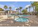Community pool and spa area with tables and chairs, surrounded by Palm trees at 950 Seven Hills Dr # 2418, Henderson, NV 89052