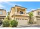 Attractive two-story tan house with a balcony, attached two-car garage, and tidy landscaping at 9617 Sharp Horn Ct, Las Vegas, NV 89149