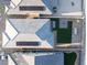 An aerial view highlights the rooftops and backyards of modern homes with solar panels and desert landscaping at 10216 Chrysolite Pl, Las Vegas, NV 89143