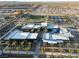 Aerial view showcasing modern building with flat roofs, surrounded by palm trees, and recreational courts in background at 10216 Chrysolite Pl, Las Vegas, NV 89143