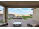 Covered patio with outdoor seating overlooking landscaped backyard and mountain views at 10216 Chrysolite Pl, Las Vegas, NV 89143