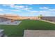 Lush backyard featuring artificial turf, desert landscaping, privacy fencing, and mountain views at 10216 Chrysolite Pl, Las Vegas, NV 89143