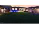 A well-lit, expansive backyard with artificial grass, gravel landscaping, and a desert sunset at 10216 Chrysolite Pl, Las Vegas, NV 89143