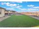 Expansive backyard with lush artificial grass, stylish landscaping, and a serene desert backdrop at 10216 Chrysolite Pl, Las Vegas, NV 89143