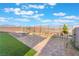 Private backyard featuring lush turf, desert landscaping, and charming patio seating, perfect for relaxation and outdoor entertaining at 10216 Chrysolite Pl, Las Vegas, NV 89143