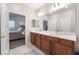 Bathroom featuring double sinks and a view to the main bedroom and bed at 10216 Chrysolite Pl, Las Vegas, NV 89143