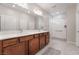 Spacious bathroom featuring double sinks, wood cabinets, and a large walk-in shower at 10216 Chrysolite Pl, Las Vegas, NV 89143