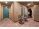 Inviting front porch with elegant chairs, a blue door, and brick flooring at 10216 Chrysolite Pl, Las Vegas, NV 89143