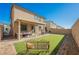 View of the backyard with covered patio, seating, artificial grass, and BBQ at 10415 Andele Ave, Las Vegas, NV 89166